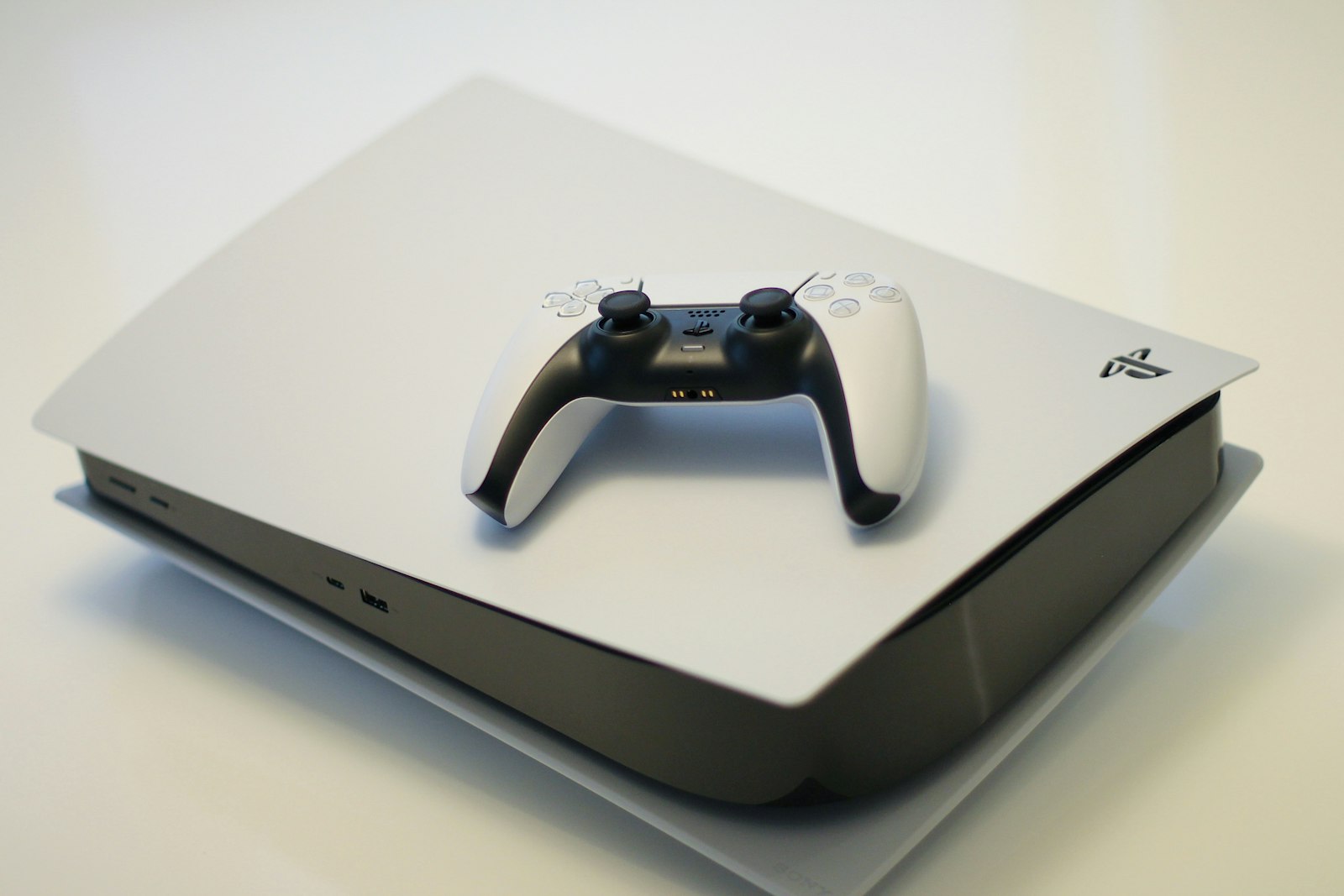 White DualSense controller resting on top of a PlayStation 5 console.